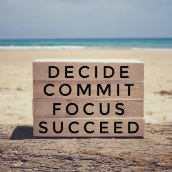 ‘Decide, commit, focus, succeed’ on a wooden blocks. With vintage styled background.